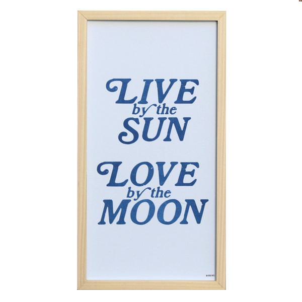 A high quality view of the sign that says 'Live by the Sun, Love by the Moon.'